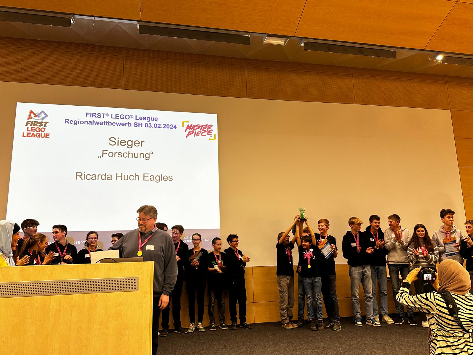 Das Team erhält auf der Bühne den Forschungspreis in Kiel