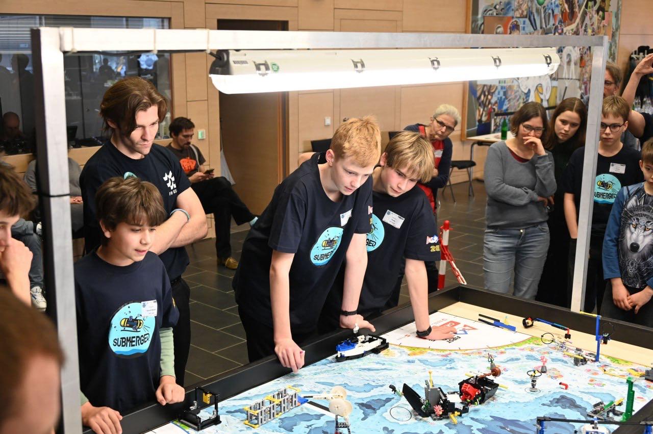 Das Team beobachtet seinen Roboter am Submerged-Spielfeld